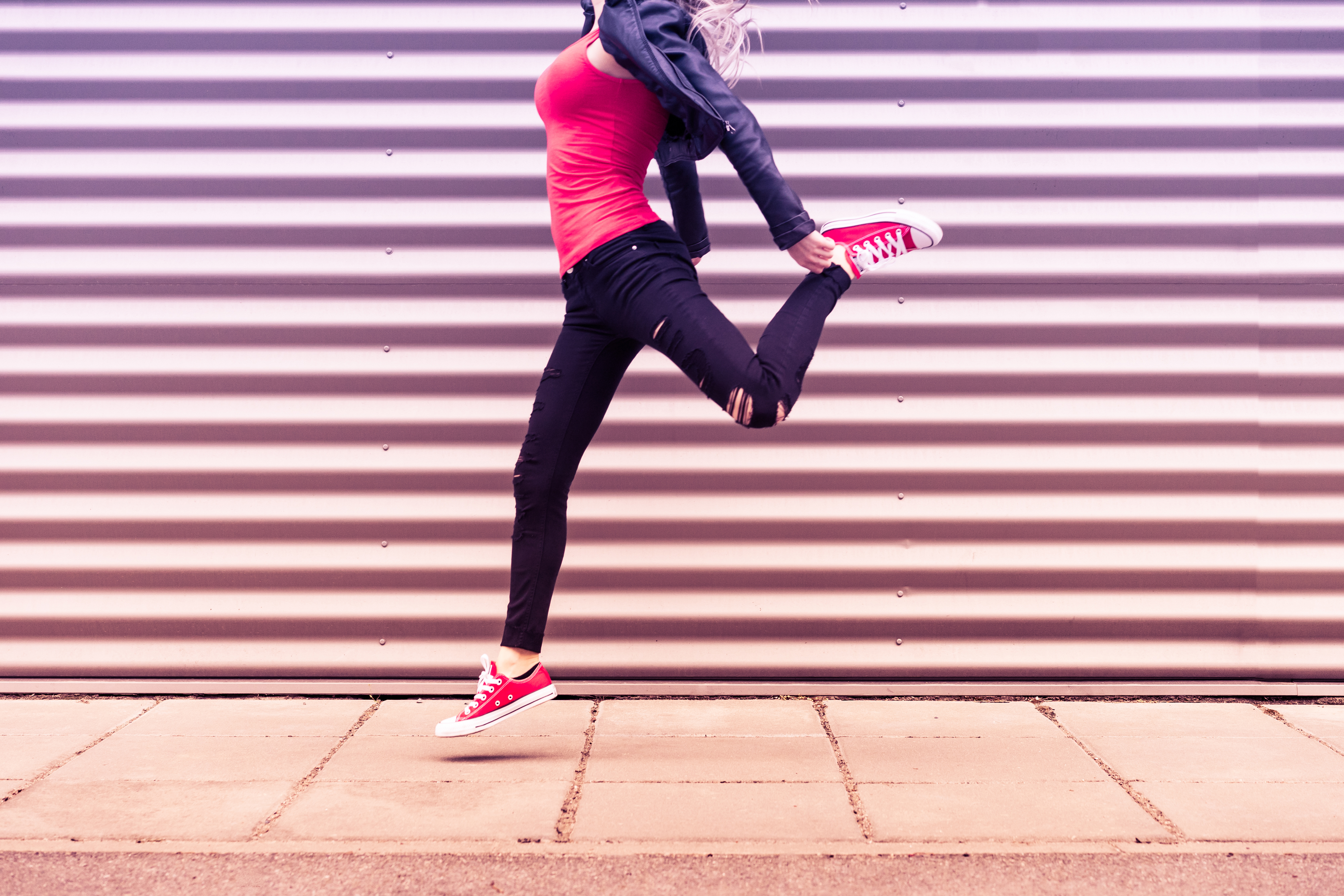 young-happy-woman-jumping-in-front-of-metal-wall-2-picjumbo-com